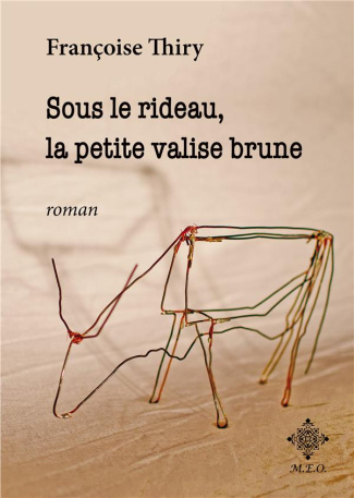 Sous le rideau, la petite valise brune